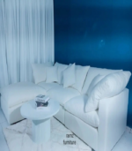 a white couch with pillows and a white table